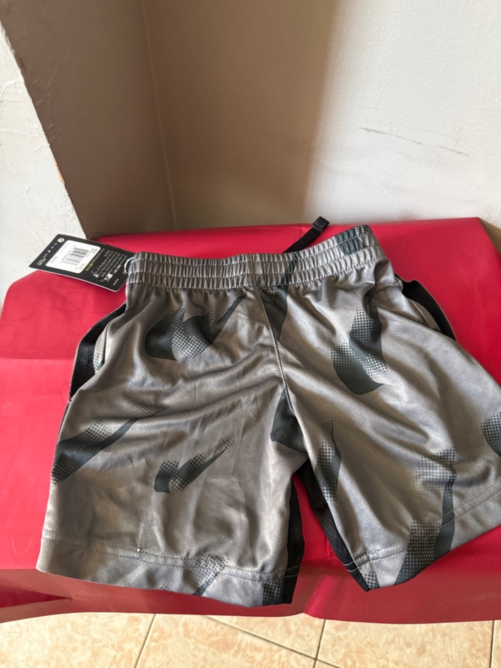 Nike Gray Athletic Shorts with Black Swoosh Pattern